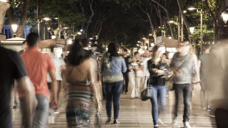 Diverses persones passegen per la Rambla de nit