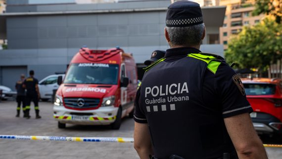 Un agent de la Guàrdia observa una parella de bombers de Barcelona